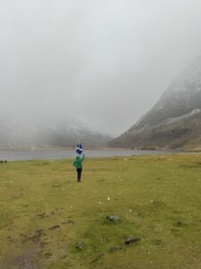 Person in Green Raincoat waves Scottish Flag