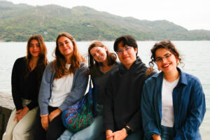 5 people with mountain and ocean in the background