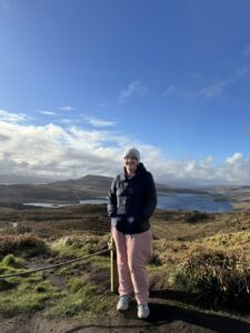 Girl stands with mountain and lake in background