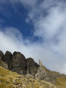 Steep Rock Formation with dark blue sky and clouds above.