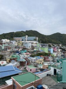 Busan Gamcheon Village which is made up of several colorful houses and buildings against a tall mountain range.